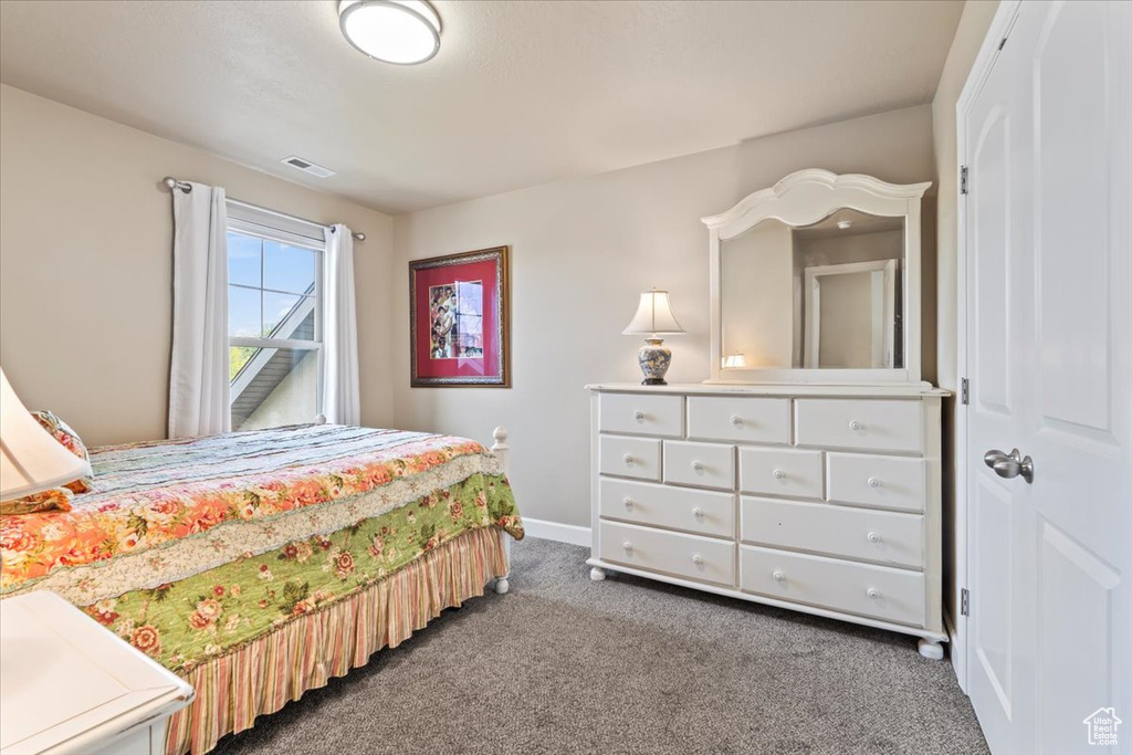 Bedroom featuring carpet and baseboards
