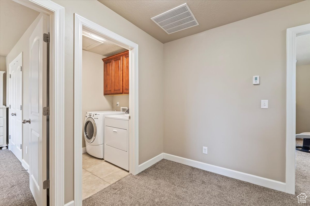 Washroom with light colored carpet and washing machine and dryer