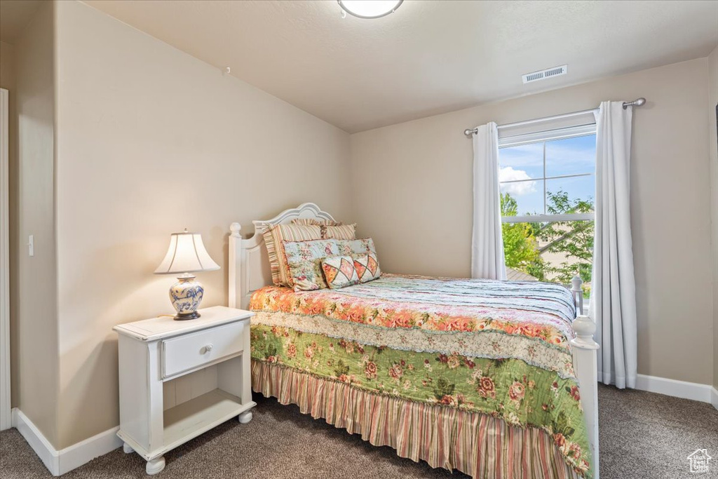 Bedroom featuring dark colored carpet and baseboards