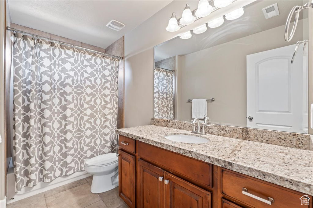 Bathroom featuring vanity, tile patterned floors, and shower / bath combination with curtain