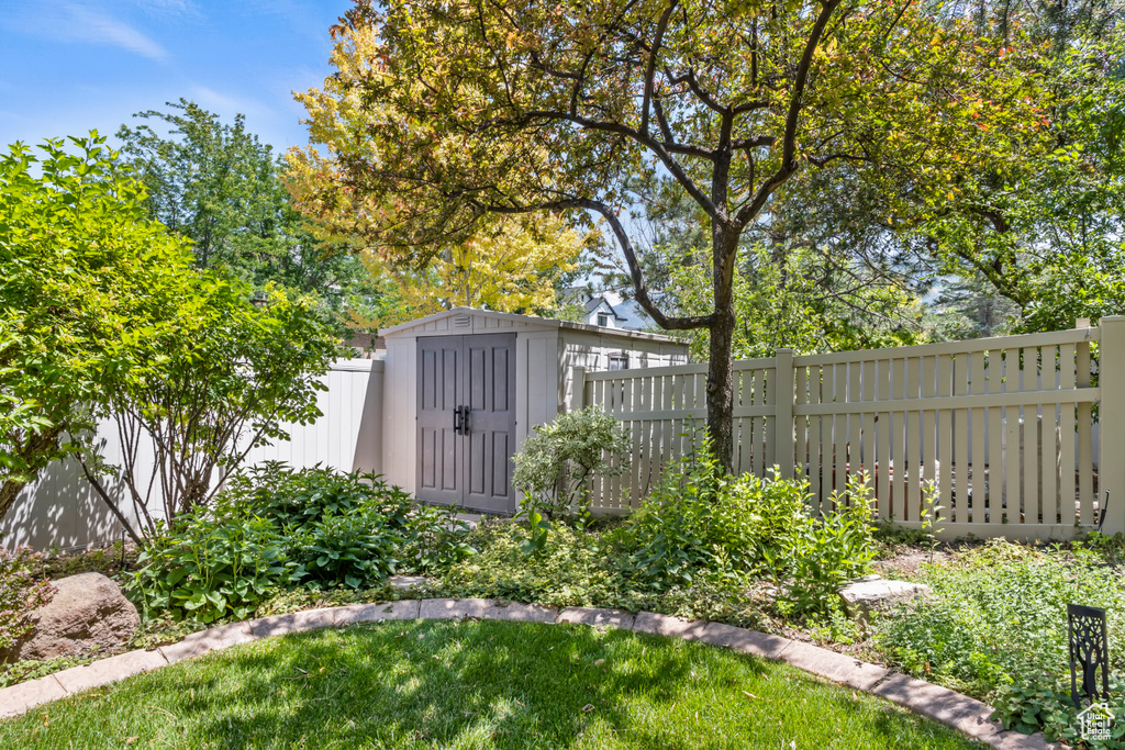 Fenced backyard featuring a storage shed
