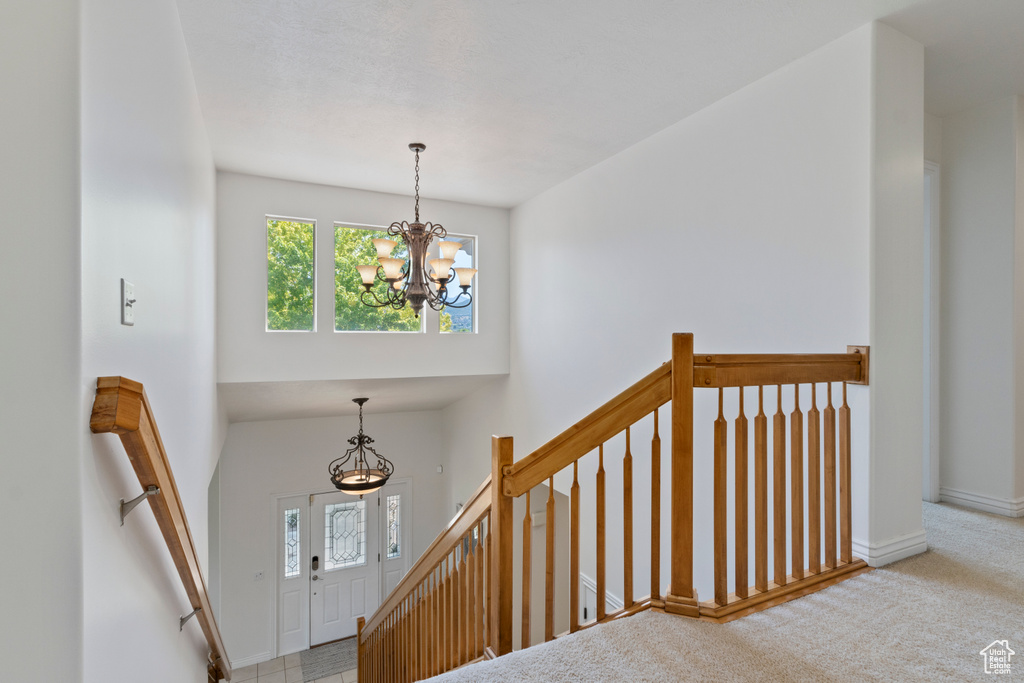 Stairway featuring a chandelier and carpet flooring