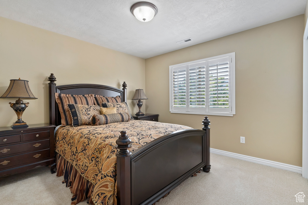 Bedroom with light carpet and baseboards