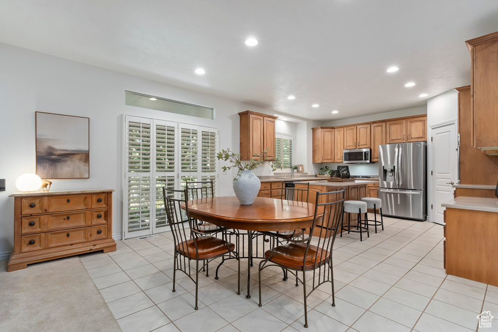 Dining space with light tile patterned flooring and recessed lighting