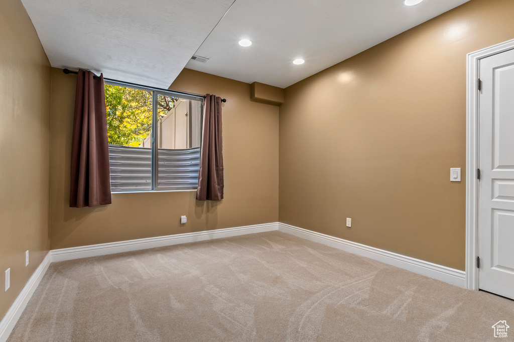 Carpeted empty room with baseboards and recessed lighting