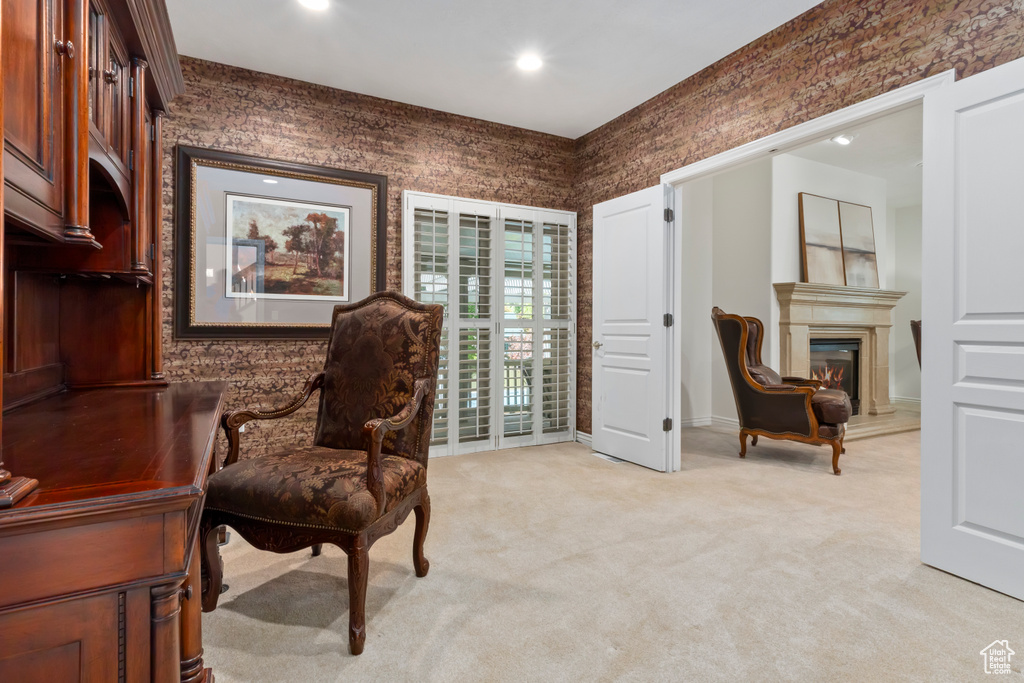 Living area with light colored carpet, recessed lighting, a glass covered fireplace, and wallpapered walls