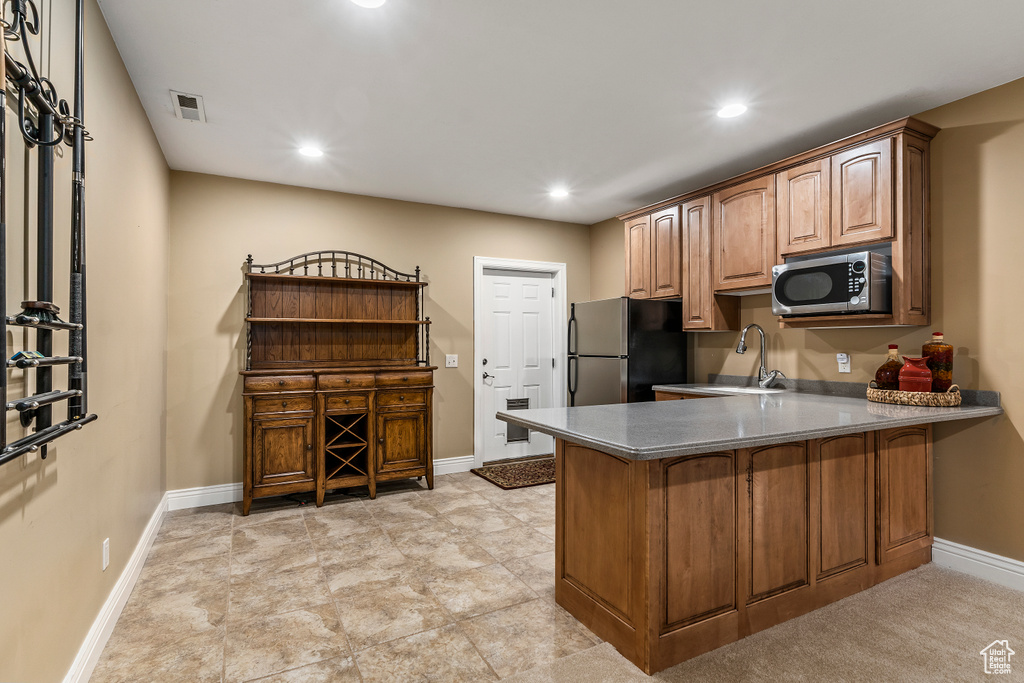 Kitchen with appliances with stainless steel finishes, a peninsula, and recessed lighting