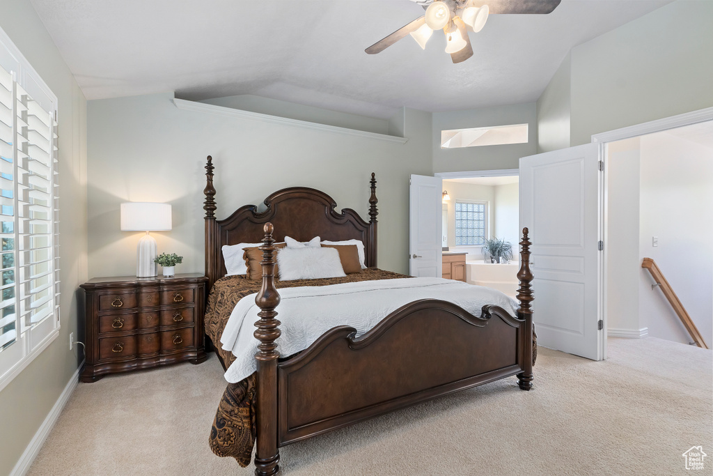 Bedroom featuring light carpet, lofted ceiling, and a ceiling fan