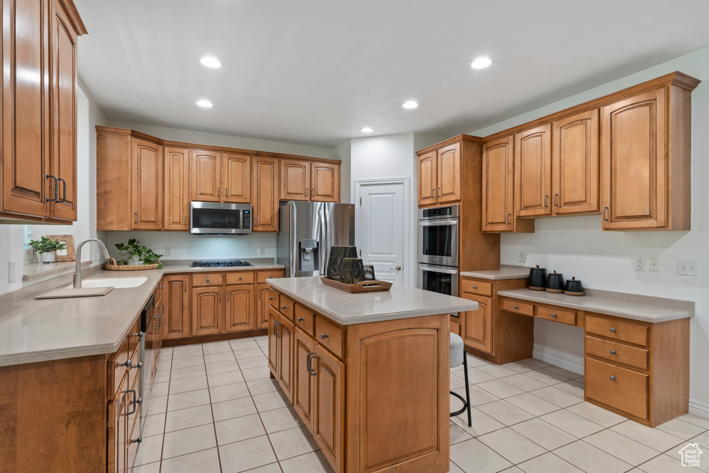 Kitchen with stainless steel appliances, light tile patterned flooring, a center island, a breakfast bar area, and recessed lighting