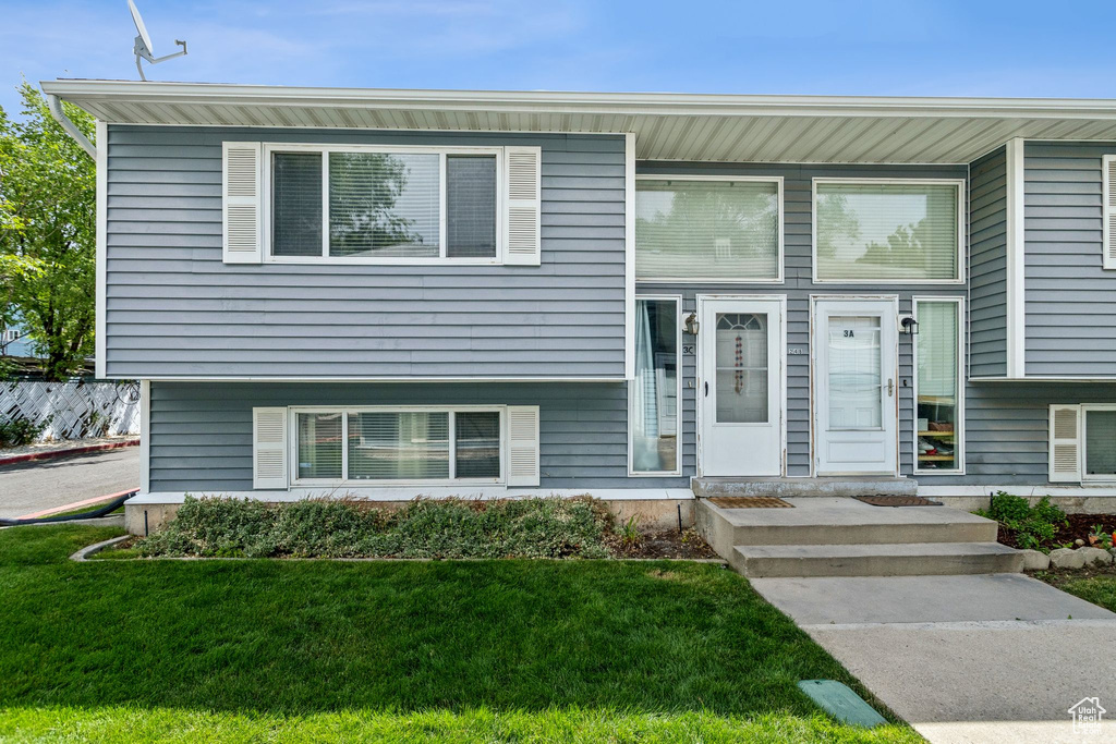Split level home with a front lawn