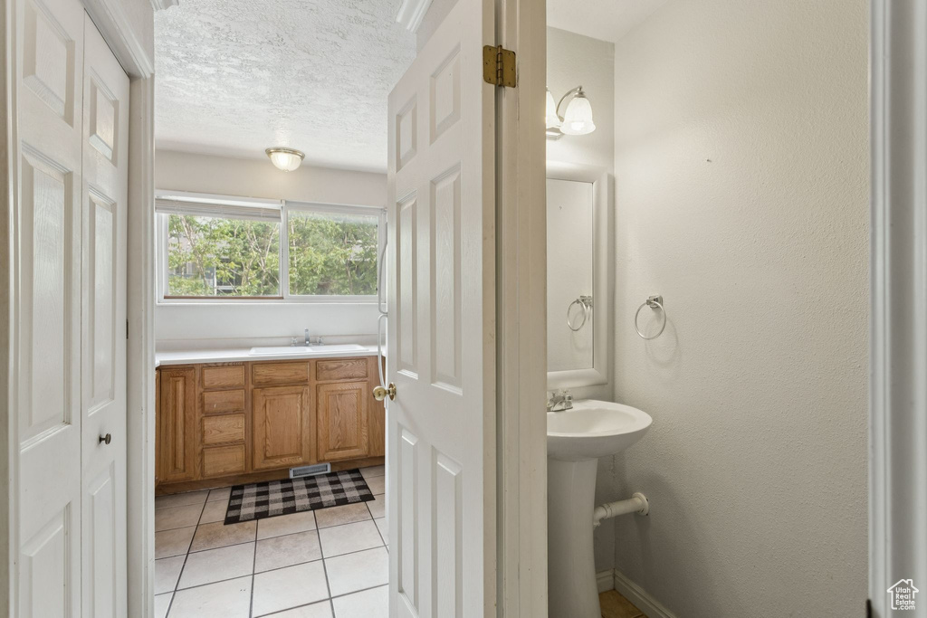 Bathroom with tile patterned flooring and a textured ceiling
