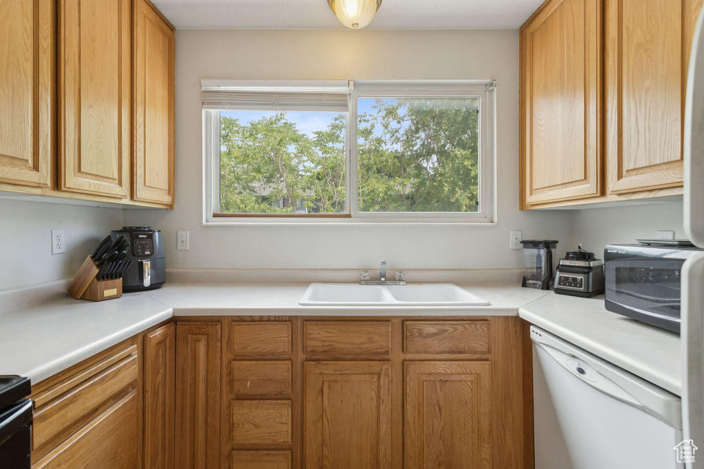Kitchen featuring white dishwasher and light countertops