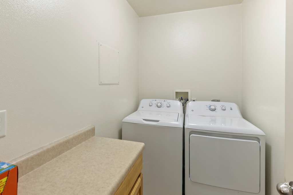 Washroom featuring washing machine and dryer and cabinet space