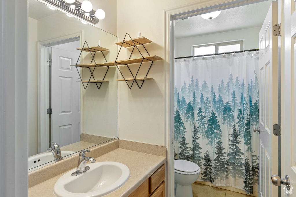 Full bathroom featuring vanity, tile patterned flooring, and curtained shower