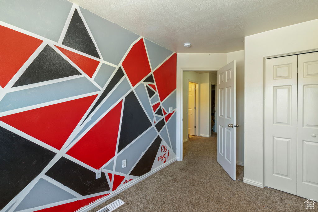 Corridor featuring carpet and a textured ceiling
