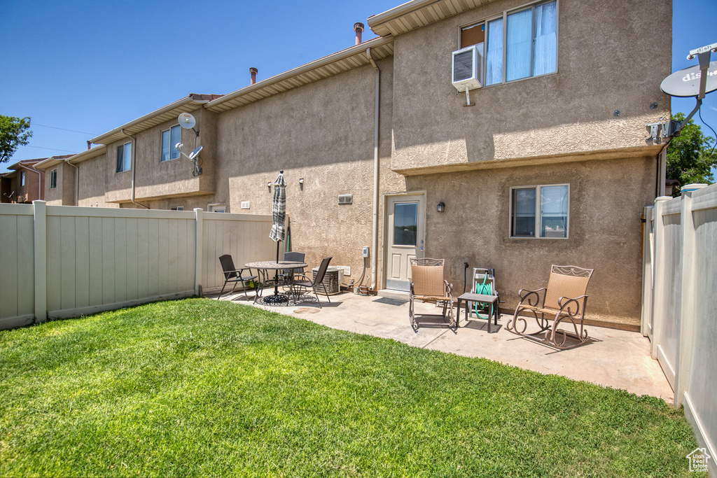 Back of house with stucco siding, a patio area, and a fenced backyard