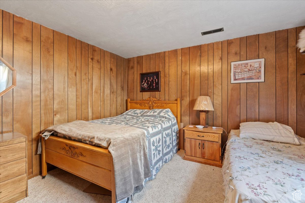 Bedroom with carpet floors and wooden walls