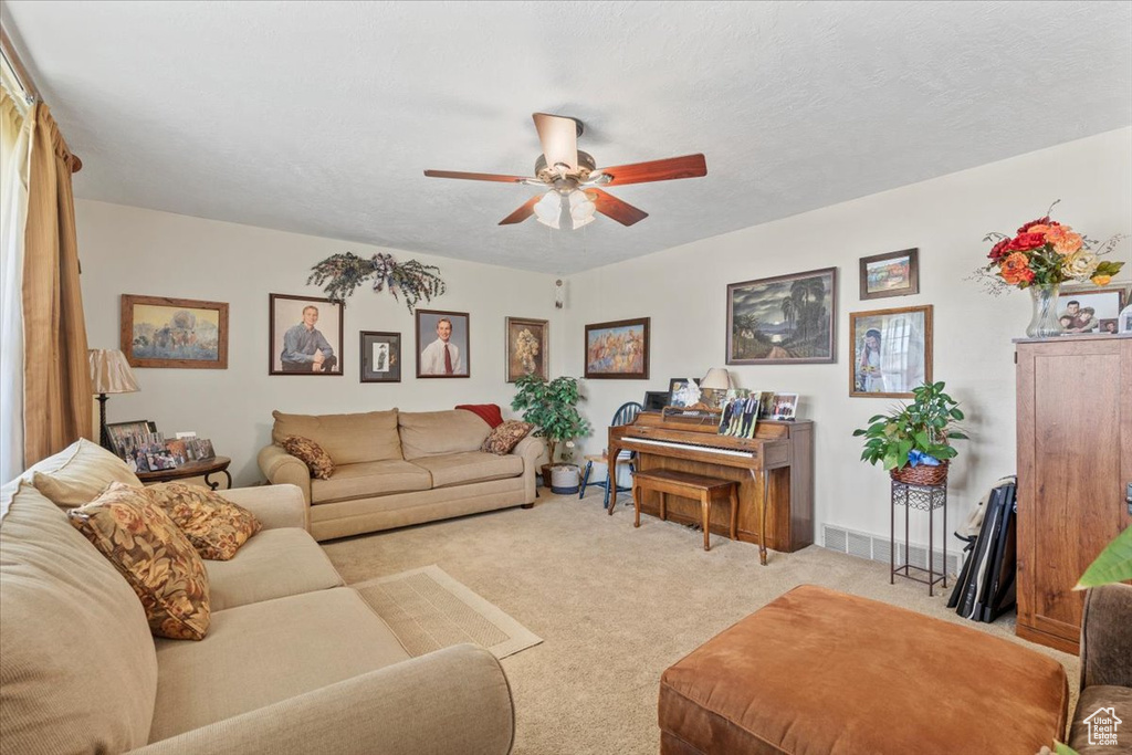 Living room featuring a ceiling fan and light colored carpet