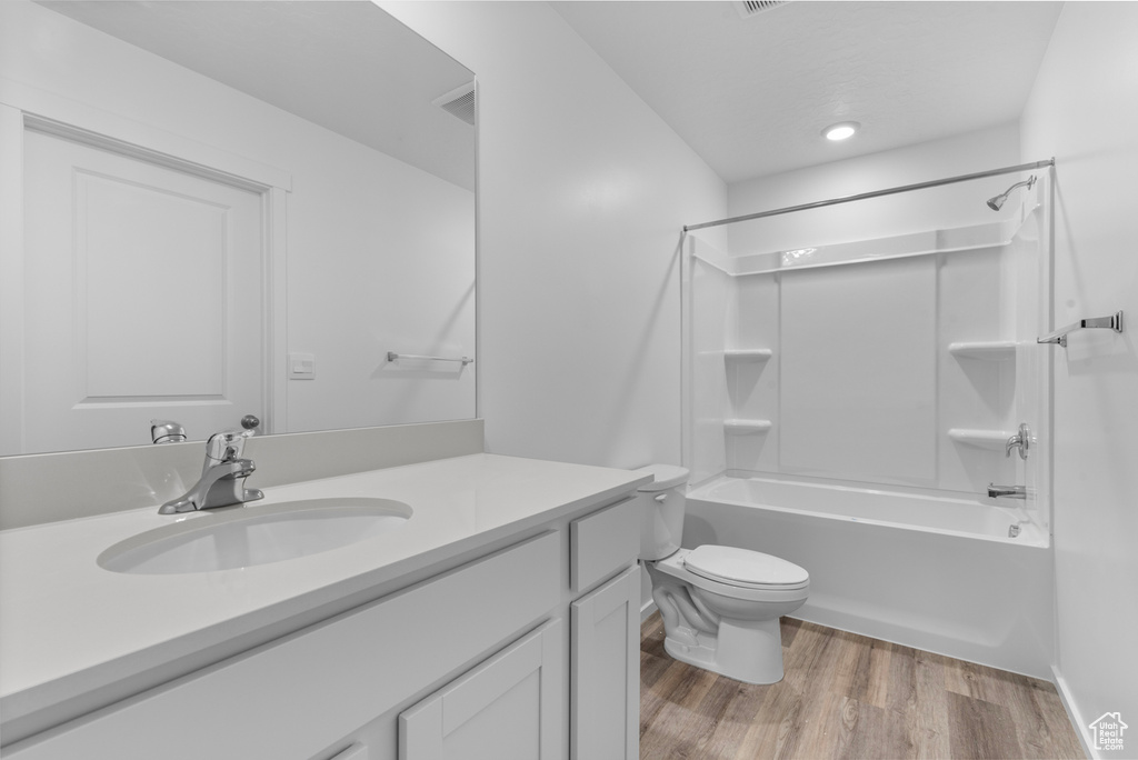 Full bath with vanity, wood finished floors, and bathtub / shower combination