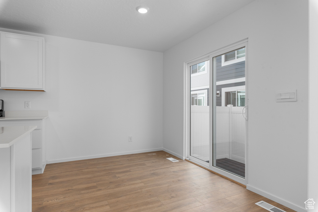 Unfurnished dining area with light wood finished floors and recessed lighting