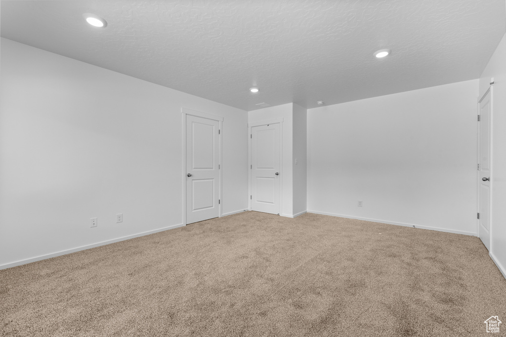 Spare room featuring light carpet, recessed lighting, and a textured ceiling