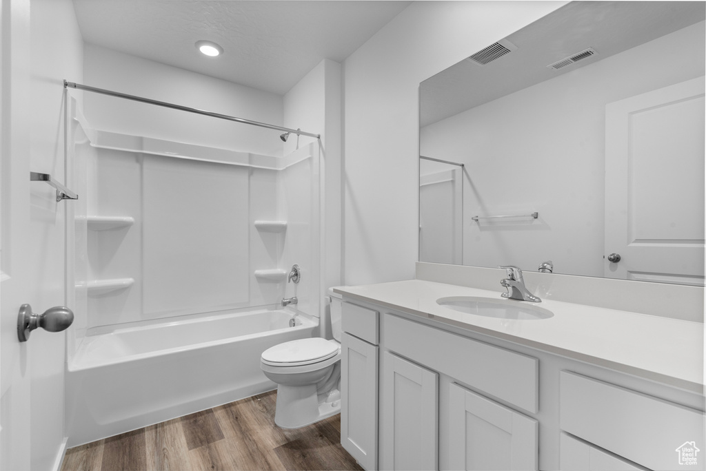 Full bathroom featuring wood finished floors, vanity, and tub / shower combination