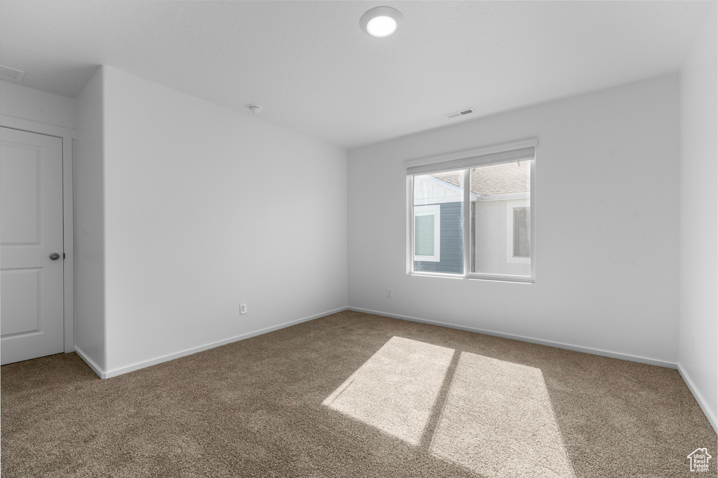 Carpeted empty room featuring baseboards