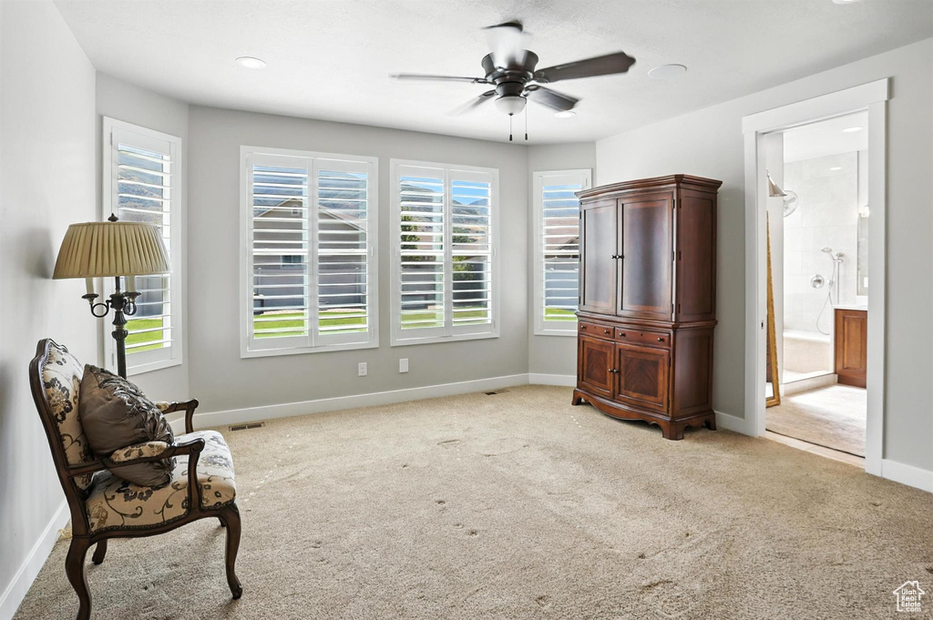 Sitting room featuring light carpet and a ceiling fan