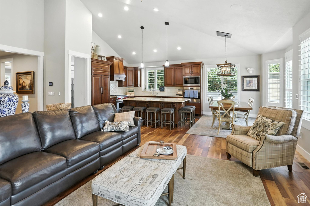Living area with wood finished floors, recessed lighting, and high vaulted ceiling