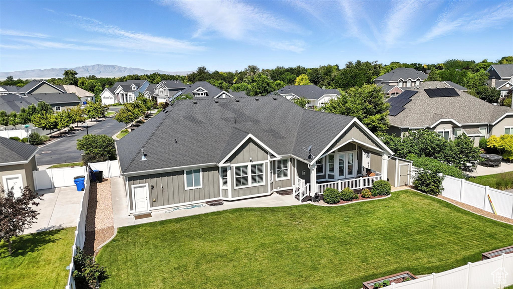 Back of property with board and batten siding, a residential view, a fenced backyard, and roof with shingles