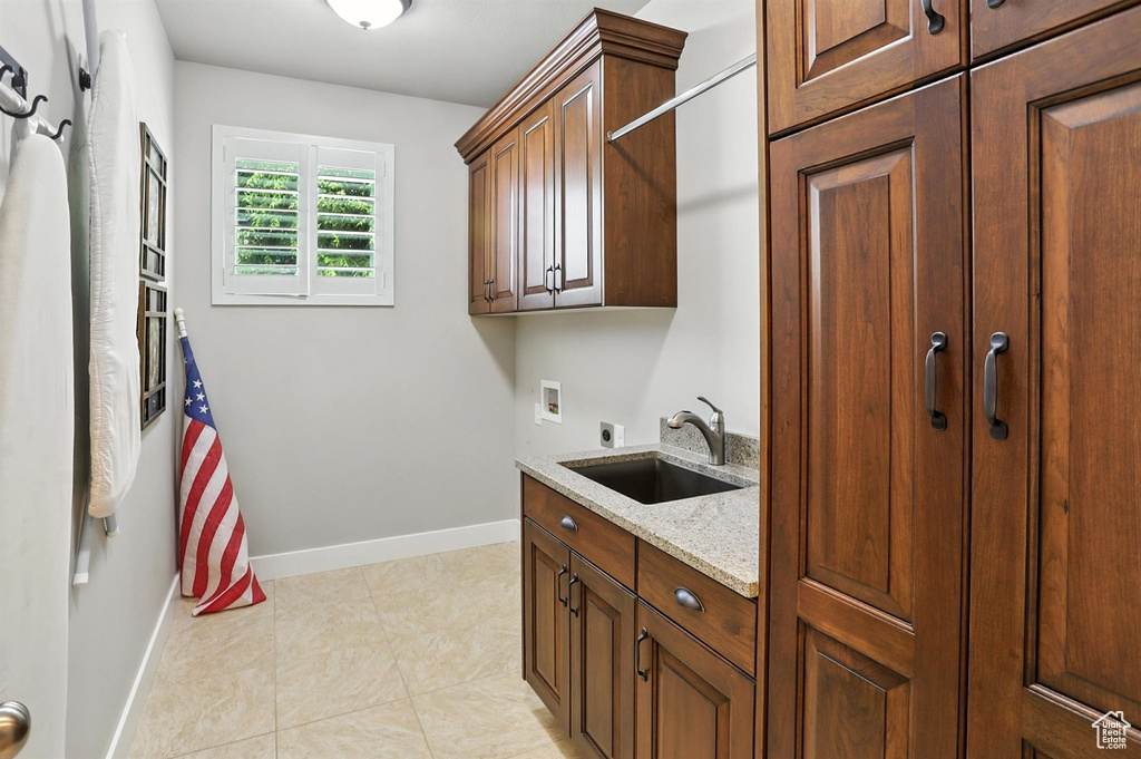 Laundry room featuring electric dryer hookup, cabinet space, washer hookup, and light tile patterned flooring
