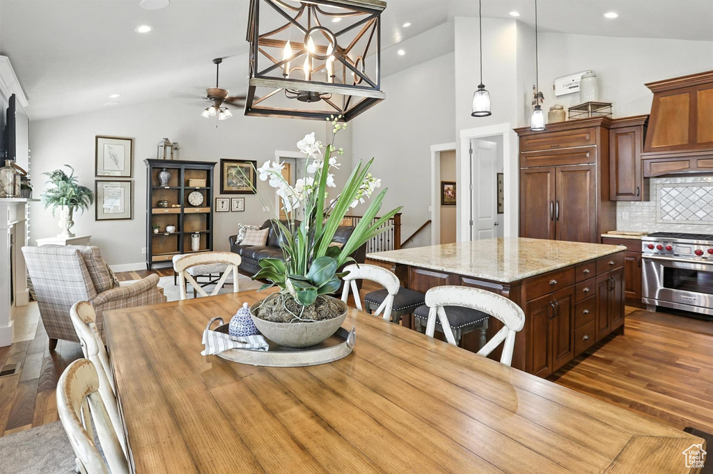 Dining room featuring wood finished floors, ceiling fan, high vaulted ceiling, and recessed lighting