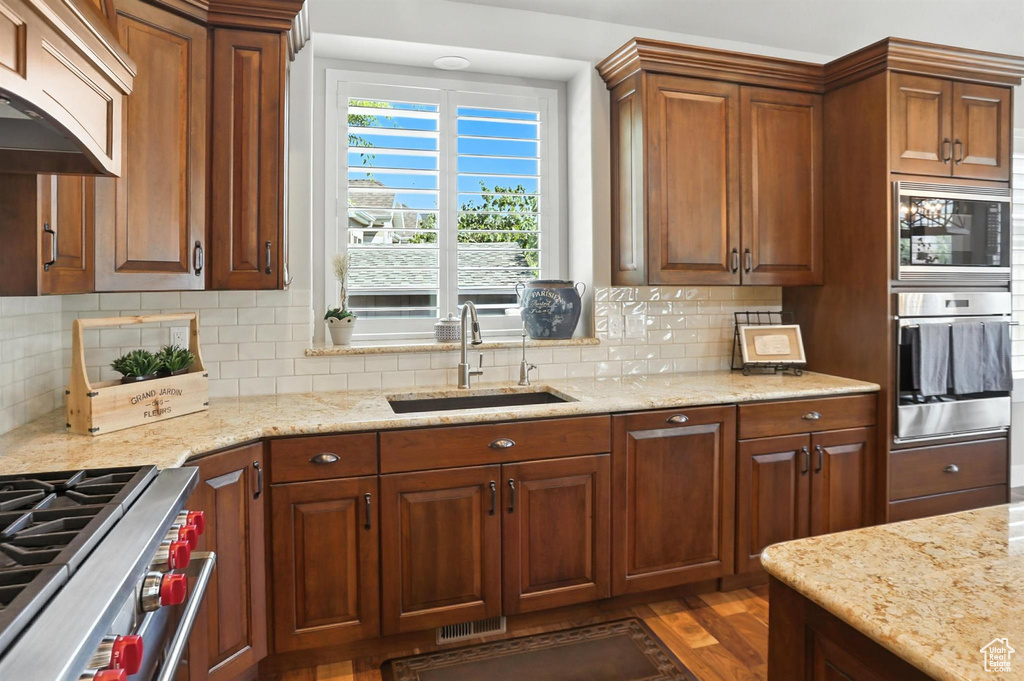 Kitchen with oven, built in microwave, extractor fan, and light stone counters