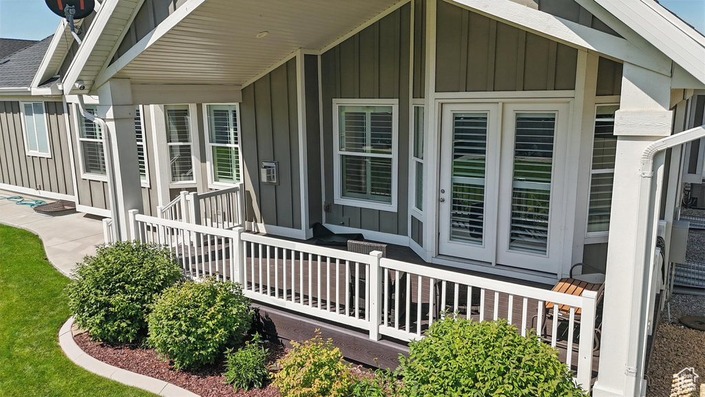 Entrance to property featuring board and batten siding and a shingled roof