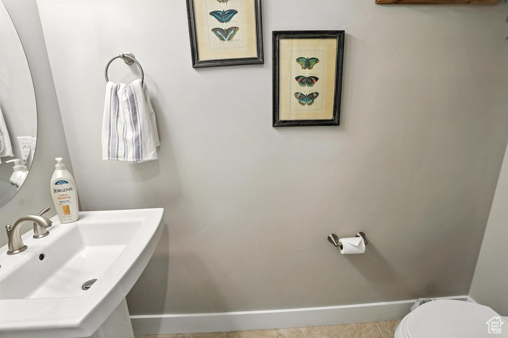 Half bath with baseboards and tile patterned floors