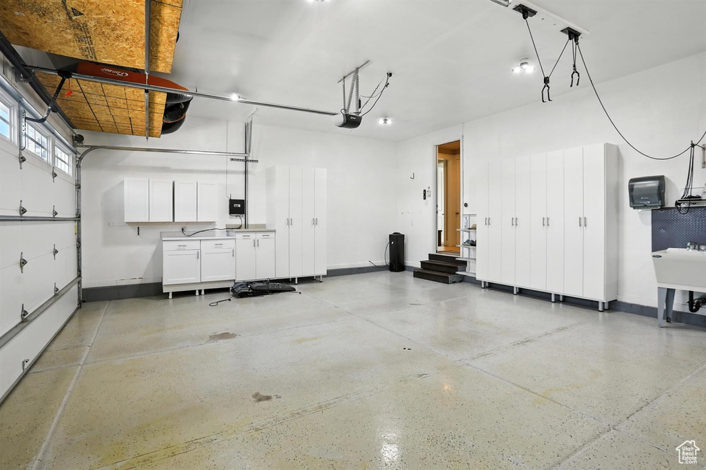 Garage featuring a garage door opener and baseboards