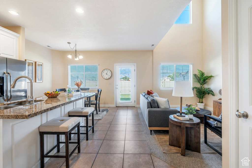Living room featuring light tile patterned floors, a chandelier, and recessed lighting