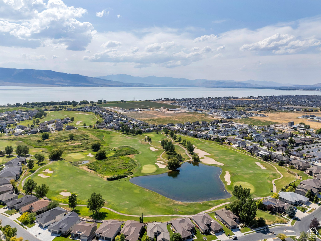Aerial view of property and surrounding area with a water and mountain view and nearby suburban area
