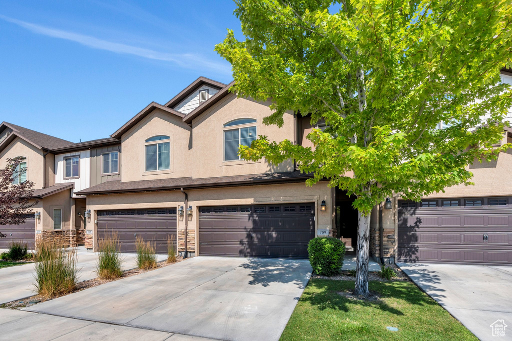 Multi unit property with stucco siding, stone siding, and concrete driveway