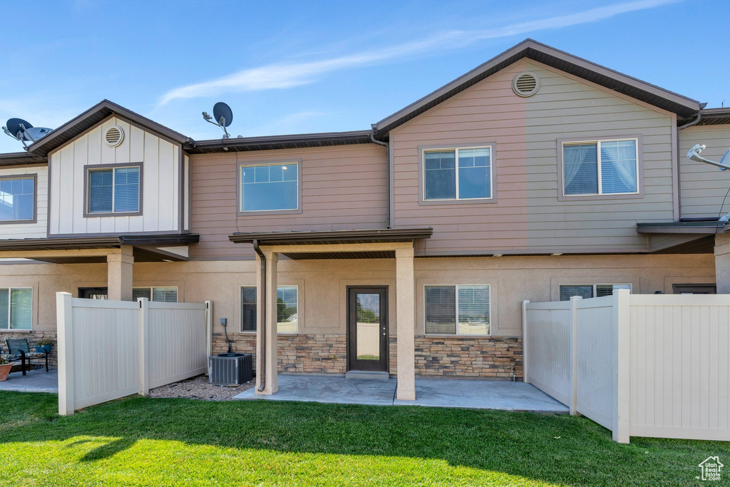 Rear view of house featuring a patio and stone siding