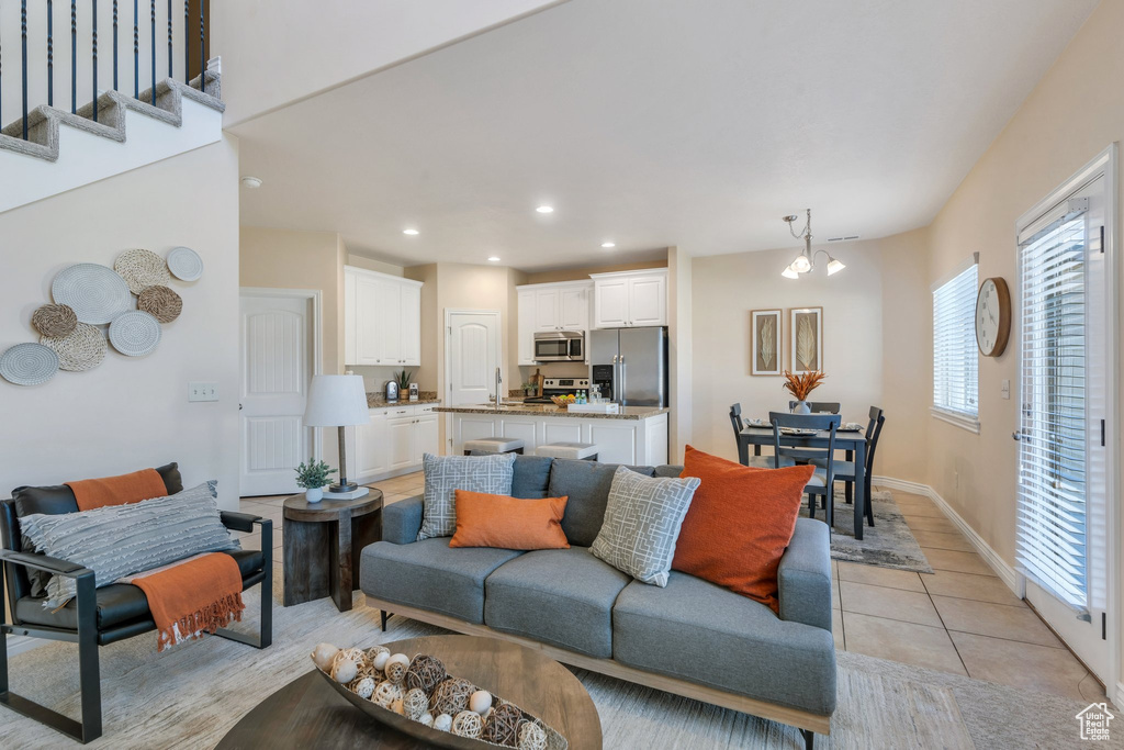 Living area with a chandelier, recessed lighting, and light tile patterned floors