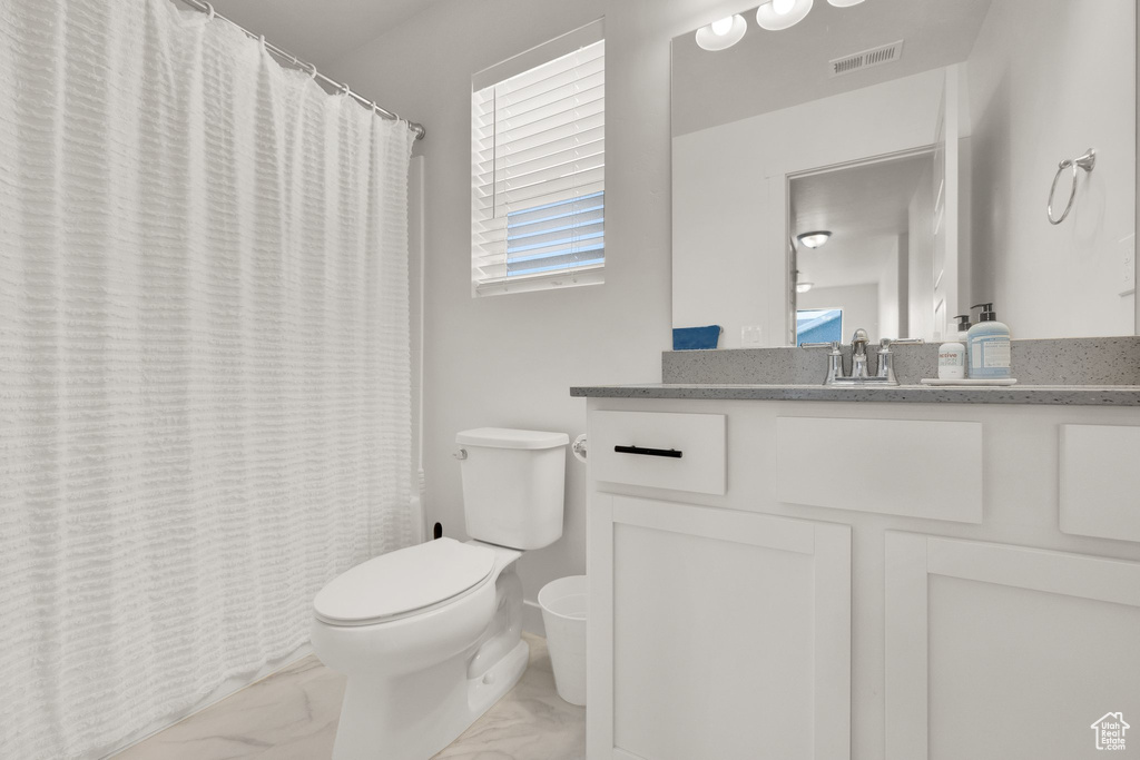 Full bath featuring marble finish flooring, vanity, and curtained shower