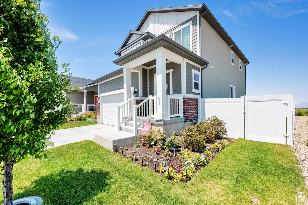 View of front of house featuring concrete driveway, an attached garage, a gate, and board and batten siding