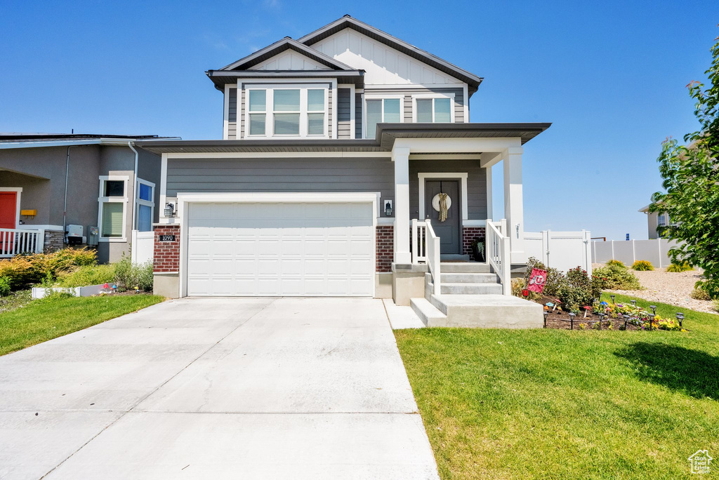 Craftsman inspired home featuring an attached garage, concrete driveway, brick siding, and a porch