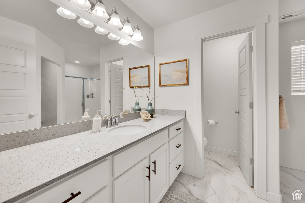Bathroom featuring marble look tiles, vanity, and a shower stall