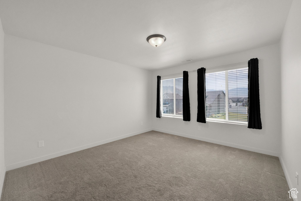 Carpeted spare room with baseboards