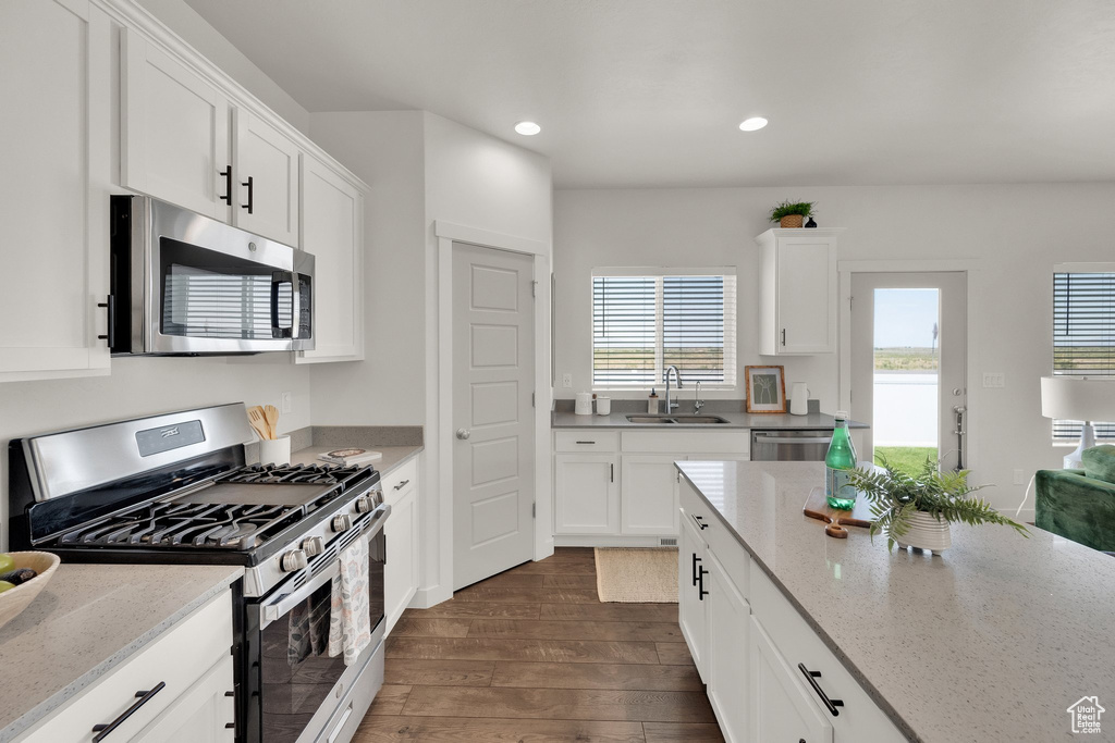 Kitchen with stainless steel appliances, dark wood finished floors, recessed lighting, plenty of natural light, and white cabinets