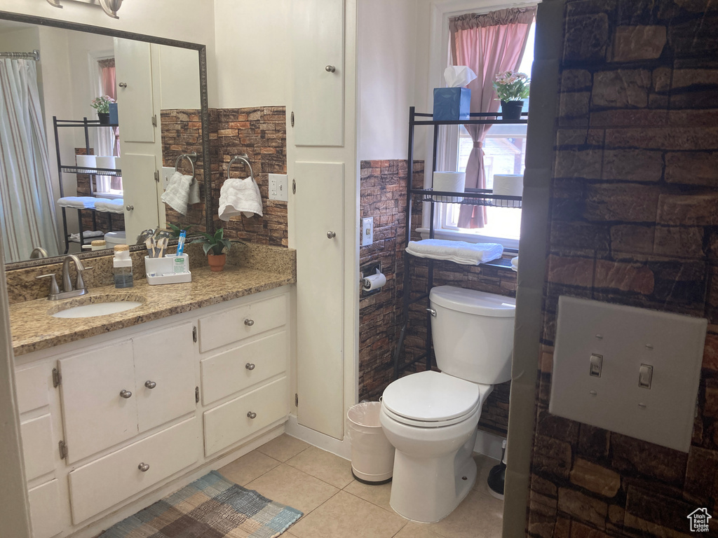Bathroom with tile patterned flooring, vanity, and a wainscoted wall