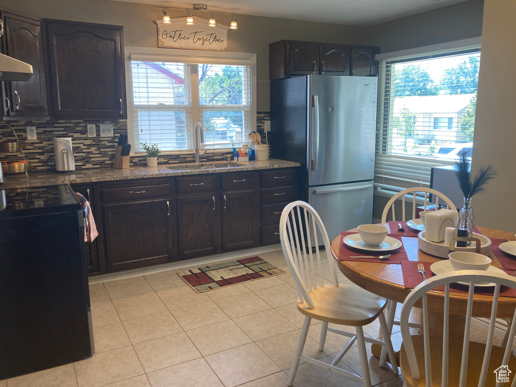 Kitchen featuring freestanding refrigerator, black range with electric stovetop, healthy amount of natural light, and decorative backsplash