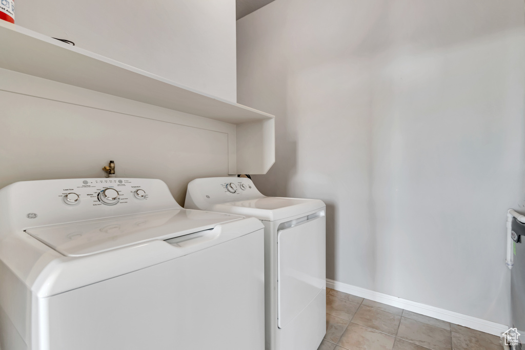Laundry room featuring independent washer and dryer and light tile patterned floors